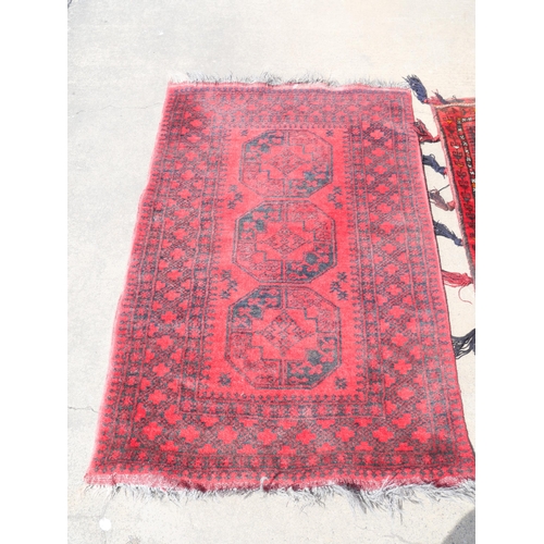 255 - An eastern red ground rug and a Turkish salt bag