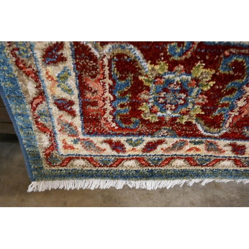 1323 - A blue ground full pile rug with all over Aztec design, 230 x 160cm