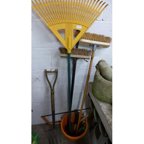 2231 - A quantity of garden tools including bow saw, rakes, brushes, a bucket, pitch fork, etc.