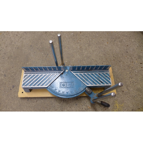 2236 - A metal fire pit with four assorted metal post spikes and a manual mitre saw