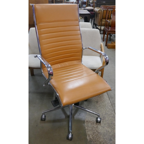 83 - An Eames style chrome and tan leather revolving desk chair