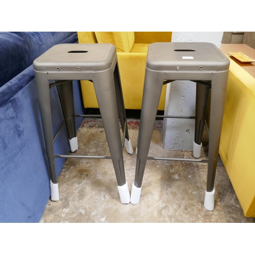 A pair of Tolix style bar stools with rustic patina