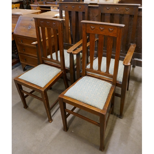 194 - A set of four Arts and Crafts Liberty & Co. style carved oak dining chairs