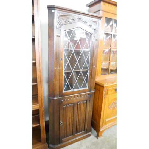 216 - A carved oak linenfold free standing corner cabinet