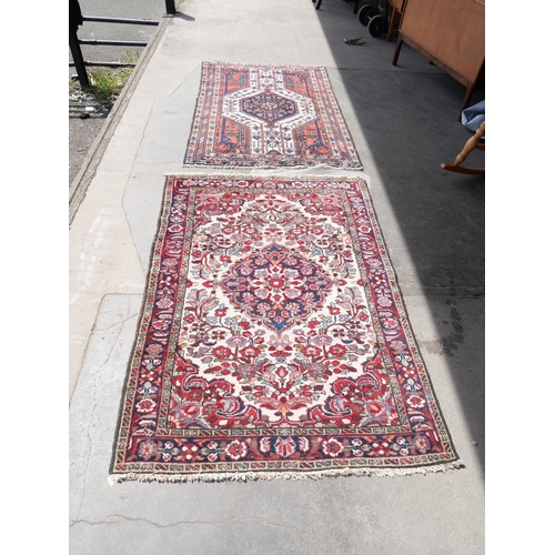 219 - Two Persian terracotta ground rugs