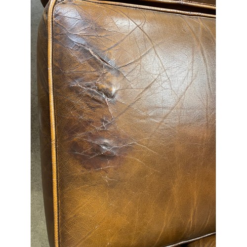 87 - A chestnut brown leather two seater Chesterfield settee