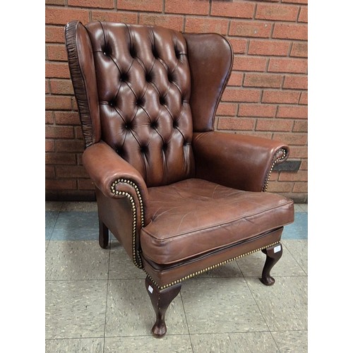 126 - A chestnut brown leather wingback armchair