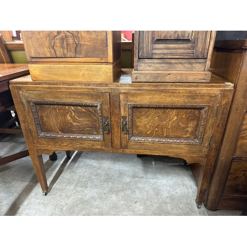 246 - A carved oak cupboard, two pot cupboards, coffee table and a printers tray