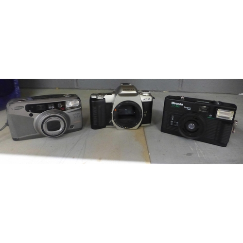 1002 - A box of cameras including basic 35mm cameras, a Canon Powershot G2 digital camera, Polaroid cameras... 