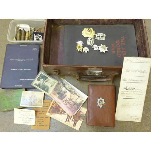 720 - A suitcase containing military items from WWI onwards, assorted cap badges including Glasgow Highlan... 