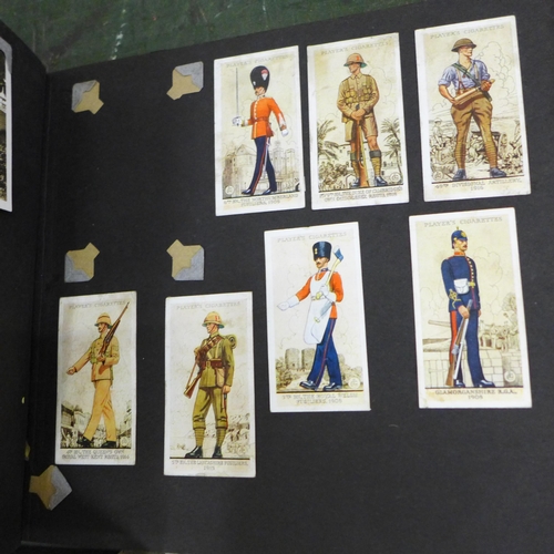 752 - A box of mixed postcards, two albums of cigarette cards and photographs, framed prints of soldiers a... 