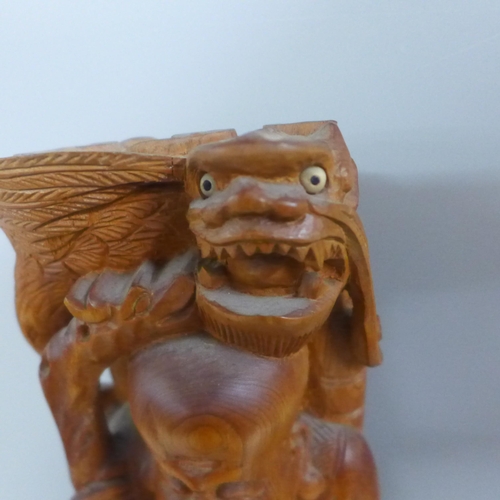 775 - An oriental wooden carving with bone inset eyes, 39.5cm