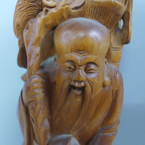 775 - An oriental wooden carving with bone inset eyes, 39.5cm