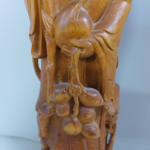 775 - An oriental wooden carving with bone inset eyes, 39.5cm