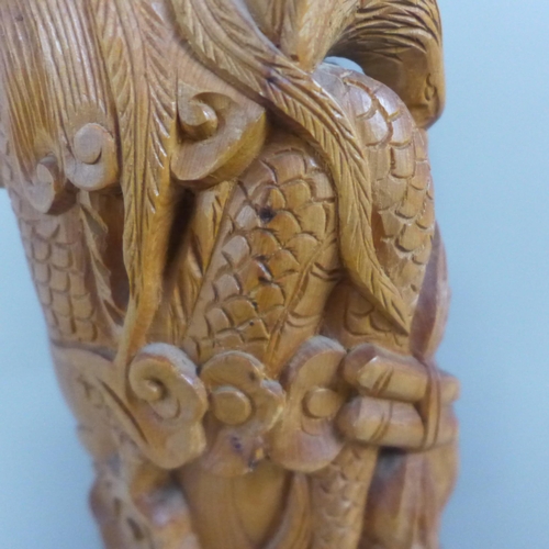 775 - An oriental wooden carving with bone inset eyes, 39.5cm