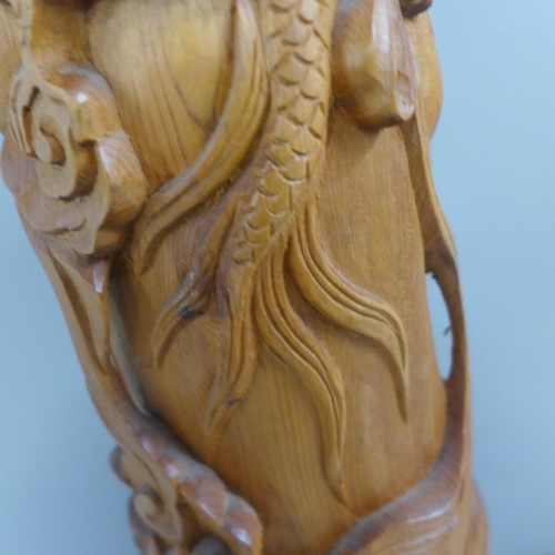 775 - An oriental wooden carving with bone inset eyes, 39.5cm