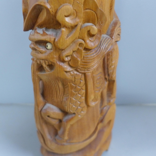 775 - An oriental wooden carving with bone inset eyes, 39.5cm