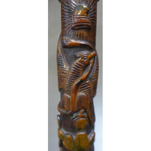 783 - A carved wooden walking stick, tropical hardwood, decorated with snakes, lizards, birds and mythical... 