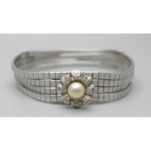 848A - An articulated four row white metal bracelet with faux pearl centre flower fastener and safety catch... 