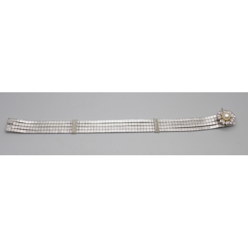 848A - An articulated four row white metal bracelet with faux pearl centre flower fastener and safety catch... 