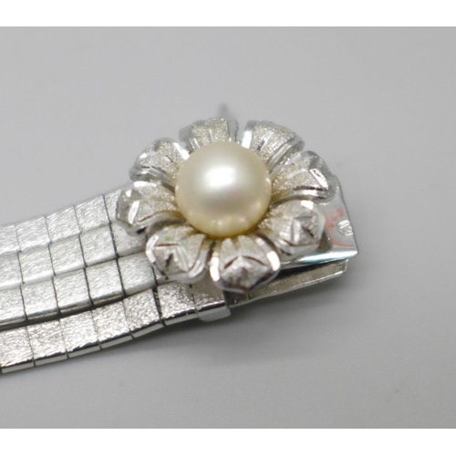 848A - An articulated four row white metal bracelet with faux pearl centre flower fastener and safety catch... 