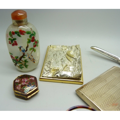 857 - An oriental scent bottle, a seal, an enamelled pill box, a silver covered scene, etc.