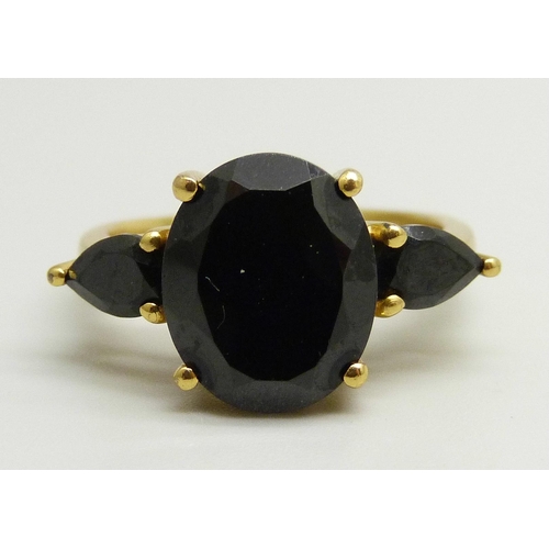 868 - A silver gilt ring set with three black stones, O