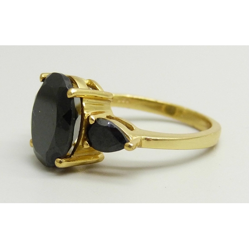 868 - A silver gilt ring set with three black stones, O