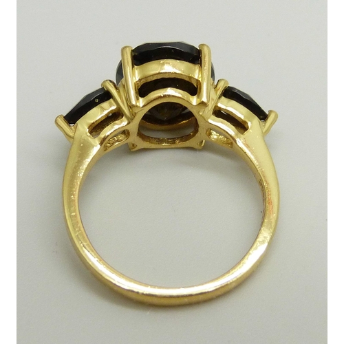 868 - A silver gilt ring set with three black stones, O