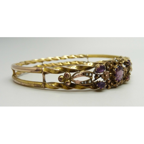 871 - A yellow metal bangle set with purple stones and seed pearls, a/f (one pearl missing, one stone repl... 