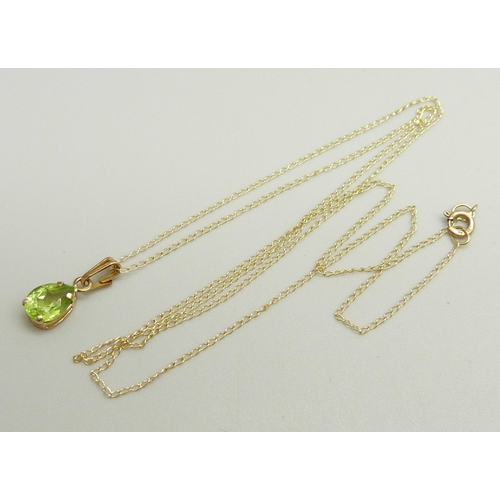 875 - A 10k gold and peridot pendant on a fine 10k gold chain, 0.8g, chain approximately 46cm, pendant 1.4... 