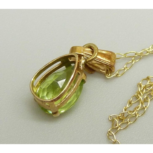 875 - A 10k gold and peridot pendant on a fine 10k gold chain, 0.8g, chain approximately 46cm, pendant 1.4... 