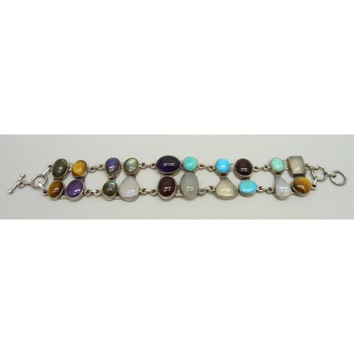 879 - A silver bracelet set with twenty gemstones including tiger's eye, amethyst, moonstone, labradorite ... 