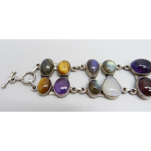 879 - A silver bracelet set with twenty gemstones including tiger's eye, amethyst, moonstone, labradorite ... 