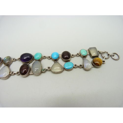 879 - A silver bracelet set with twenty gemstones including tiger's eye, amethyst, moonstone, labradorite ... 