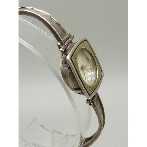 885 - A lady's silver wristwatch with hammered design bezel and strap, hallmarked on the clasp with plaque... 