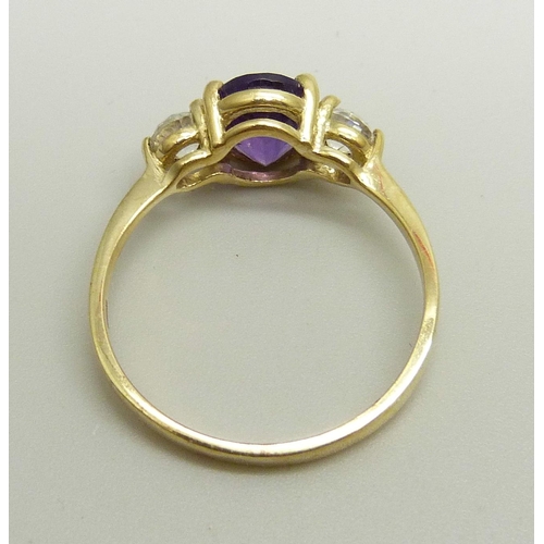 895 - A 9ct gold ring set with a central amethyst and two white spinel, 2.8g, U