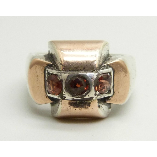 898 - A silver ring with rose gold overlay, set with three garnets, control marks to outer shank, N/O