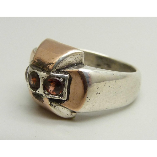 898 - A silver ring with rose gold overlay, set with three garnets, control marks to outer shank, N/O