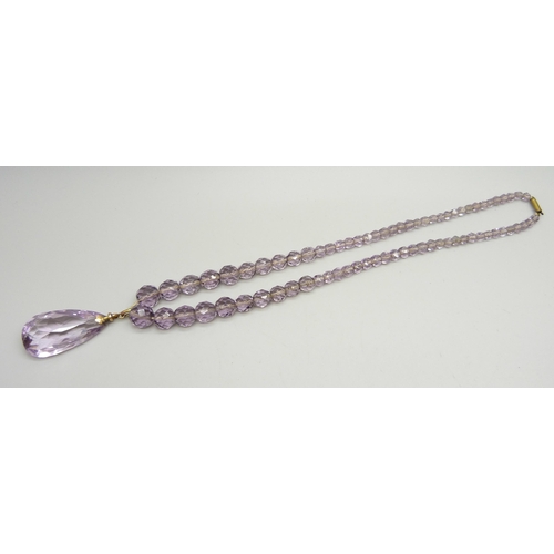 923 - A faceted amethyst bead necklace, the bale marked 9ct, with a base metal clasp, 4.6cm pendant includ... 