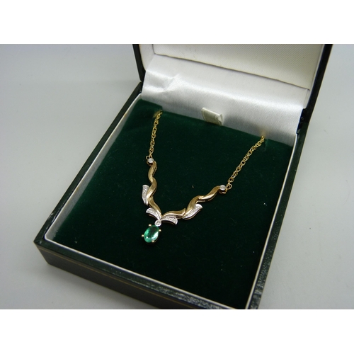 943 - A 9ct gold necklace set with diamonds and an emerald, 45cm, 3.5g