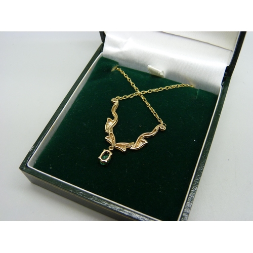 943 - A 9ct gold necklace set with diamonds and an emerald, 45cm, 3.5g