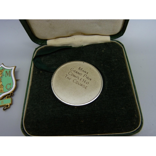 945 - A Manx Grand Prix medallion for completion of the course, cased, together with a badge for qualifica... 