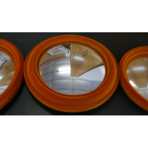 1469 - A set of seven flocked convex tangerine wall mirrors