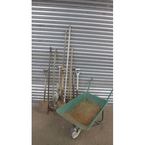 2199 - A metal wheelbarrow and a quantity of garden tools including spades, hoes, pitch forks and a rake et... 