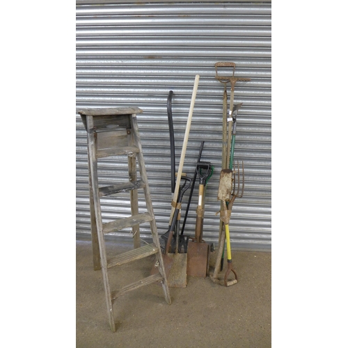 2235 - A bundle of 14 garden tools including spades, pitch forks, rakes, hoe, brush and a hose pipe and ree... 