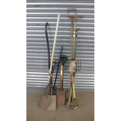 2235 - A bundle of 14 garden tools including spades, pitch forks, rakes, hoe, brush and a hose pipe and ree... 