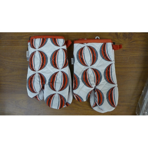 2308 - A large quantity of patterned kitchen/oven gloves and 30 x 46cm St. George Cross car flags