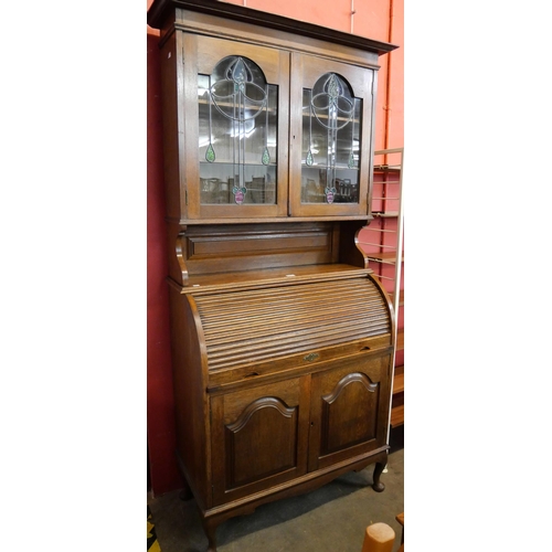 156 - An Edward VII oak tambour bureau bookcase, with Art Nouveau stained glass doors