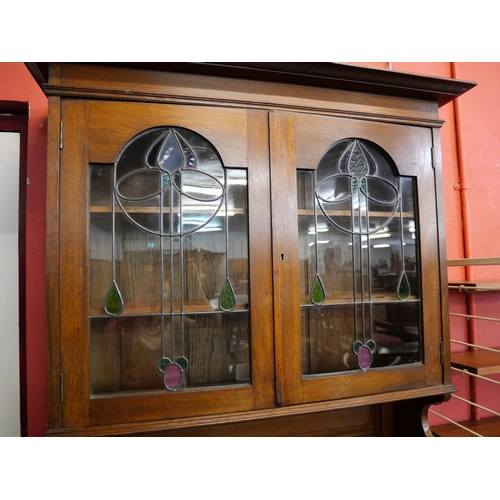 156 - An Edward VII oak tambour bureau bookcase, with Art Nouveau stained glass doors